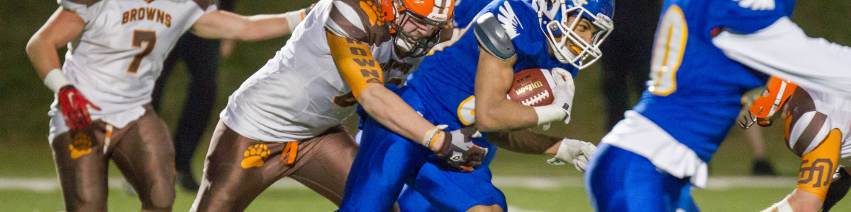A player being tackled in a football game. 